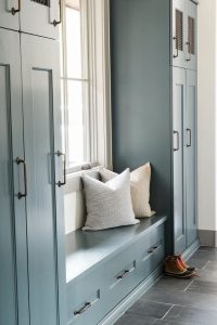 Beautiful blue cabinets provide ample storage in this mudroom