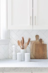 A unique kitchen backsplash with white subway tiles in a herringbone pattern