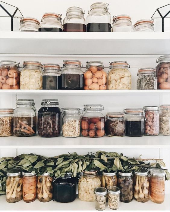 Clear glass containers in this pantry offer a beautiful visual of a wide variety of ingredients for cooking 