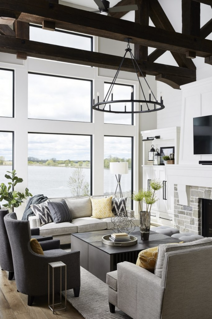 With floor-to-ceiling lake views, natural light, and exposed ceiling beams this living room is a favorite in our lake home design idea list.