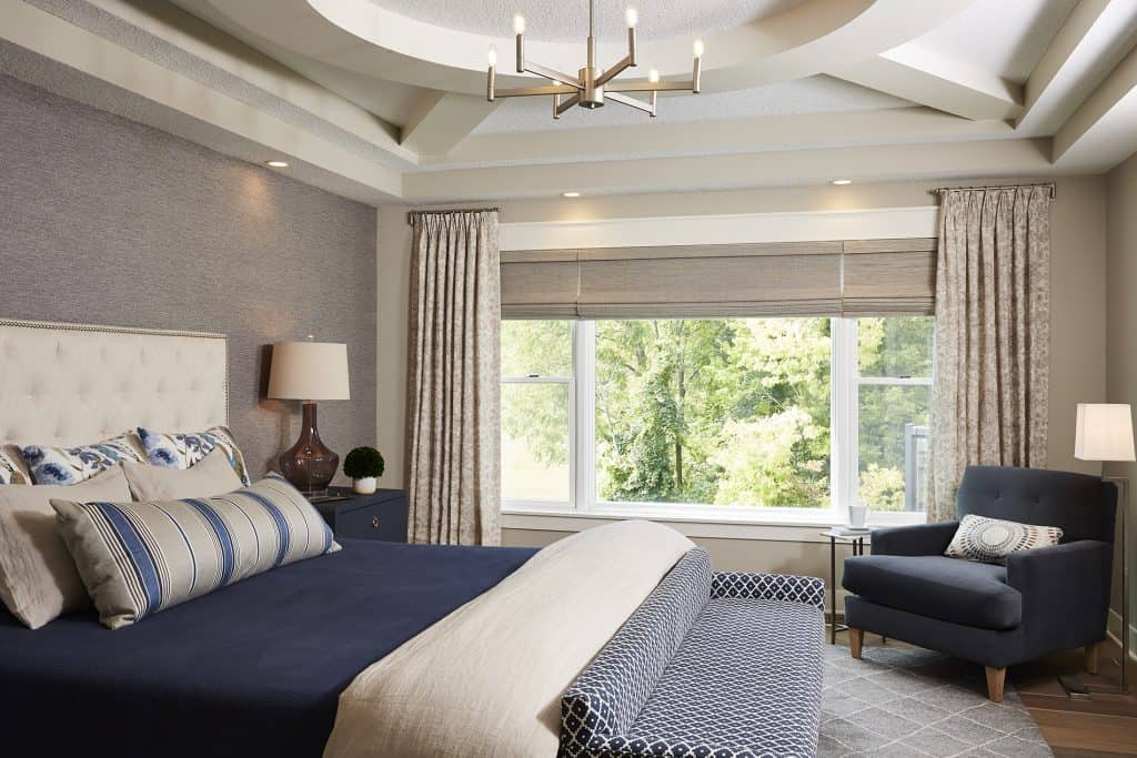 In this master bedroom, shades of blue combine with soft beige and grey to create a colorful, yet calming neutral space that wows. / Design by Carla Bast