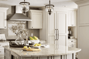 Rather than a shabby-chic set of pickled wood cabinets, this kitchen shines thanks to a creamy coat of warm white paint in a classic cabinet style. (Interior Design by Carla Bast | Carla Bast Design)