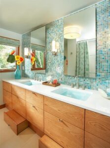 The use of color in this bathroom (ASID Showcase Home award winner for Best Use of Color) allowed us to use oak in a way that felt fresh and inviting. The cool tones in the blue and green tiled backsplash and crisp white walls helped the warmer honey oak appear balanced and updated. (Interior Design by Carla Bast | Carla Bast Design)