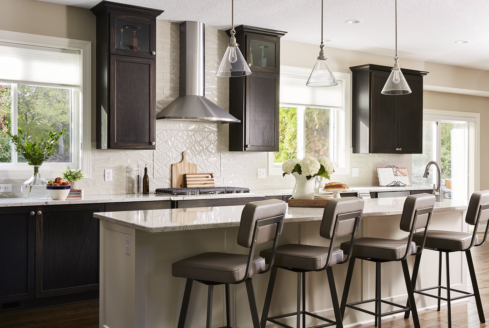 large and open kitchen with dark stained cabinets and a white backsplash