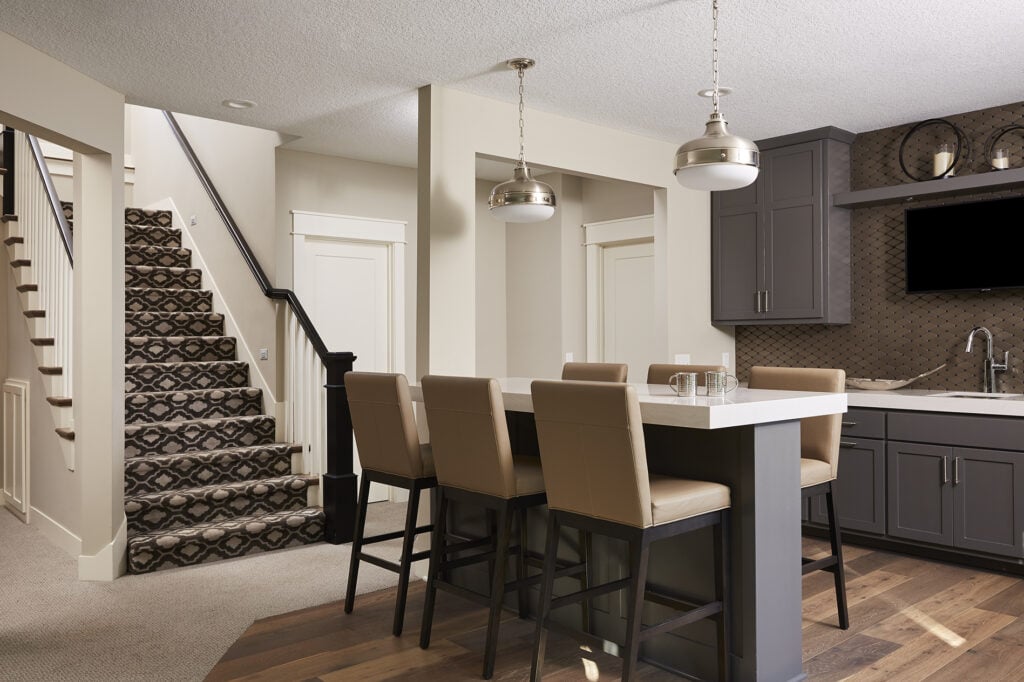 A neutral finished basement with a spacious island bar for the entire family to enjoy