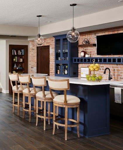 A modern blue basement bar with warm neutral colors