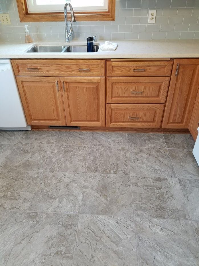 grey lvt tile with honey oak cabinets and grey subway tile