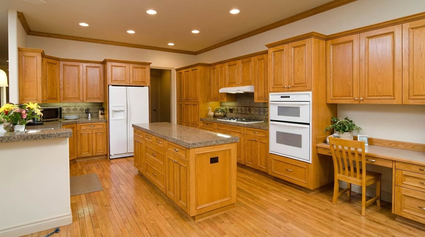 1990s kitchen with honey oak hardwood floor honey oak cabinets honey oak crown molding and a kitchen desk