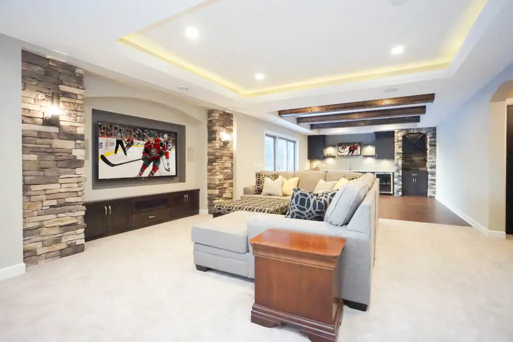 basement-with-wall-sconces-and-tray-ceiling-lighting