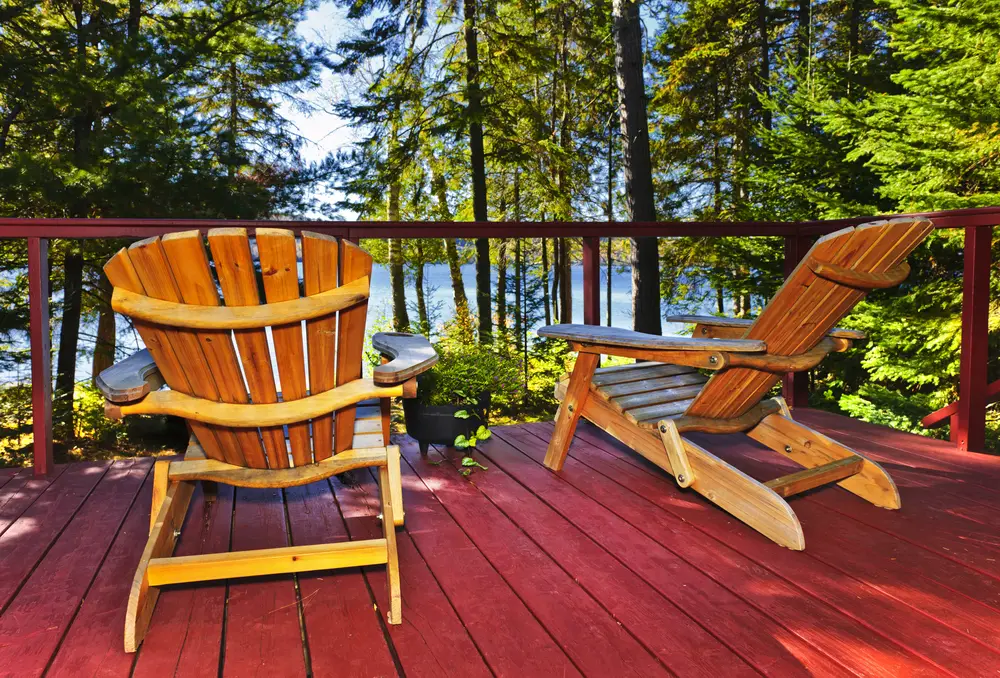 pair-of-adirondack-chairs-on-deck-overlooking-lake-in-the-woods