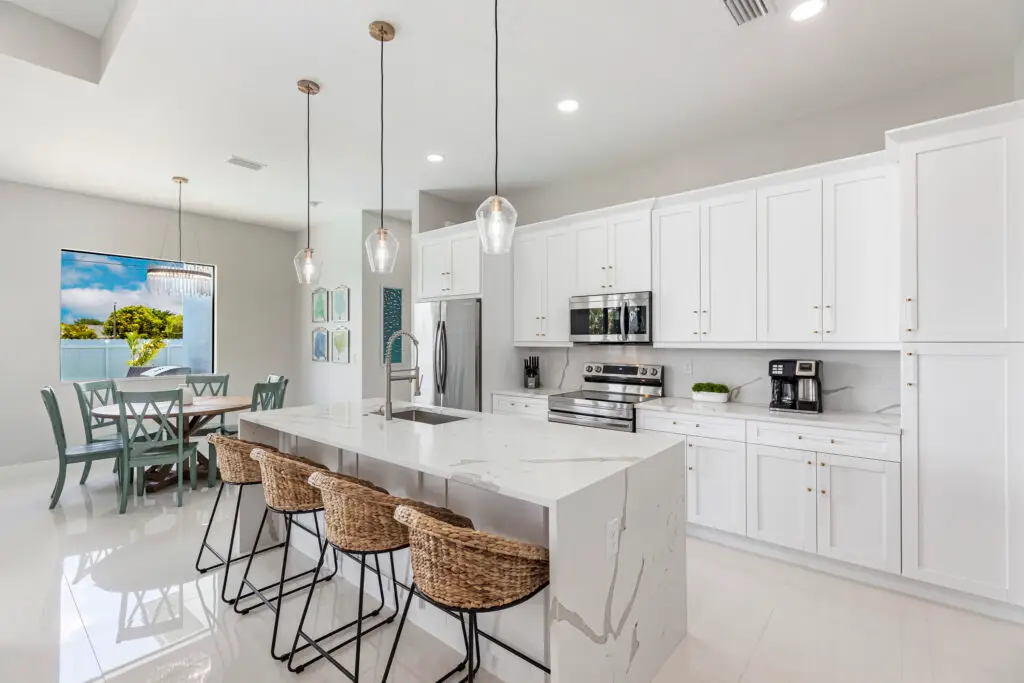 kitchen with waterfall quartz countertop island and white tile flooring