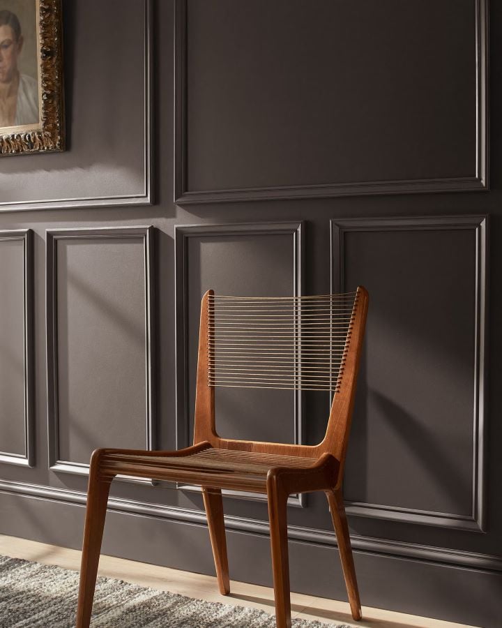 benjamin moore silhouette af-655 walls with molding and a warm wood accent chair