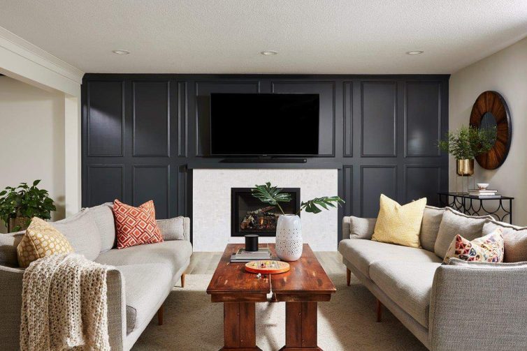 Cozy Family Room with Charcoal Enameled Paneling and Mosaic Marble Chevron Tiled Fireplace