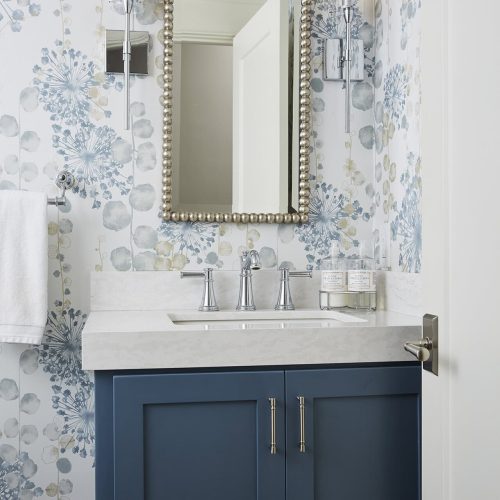 With a vibrant infusion of blues and a floral wallpaper, this renovated powder room felt bright, airy, and contemporary.