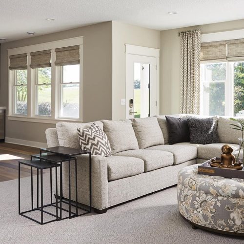 Roman shades and curtains let light inside this walkout basement